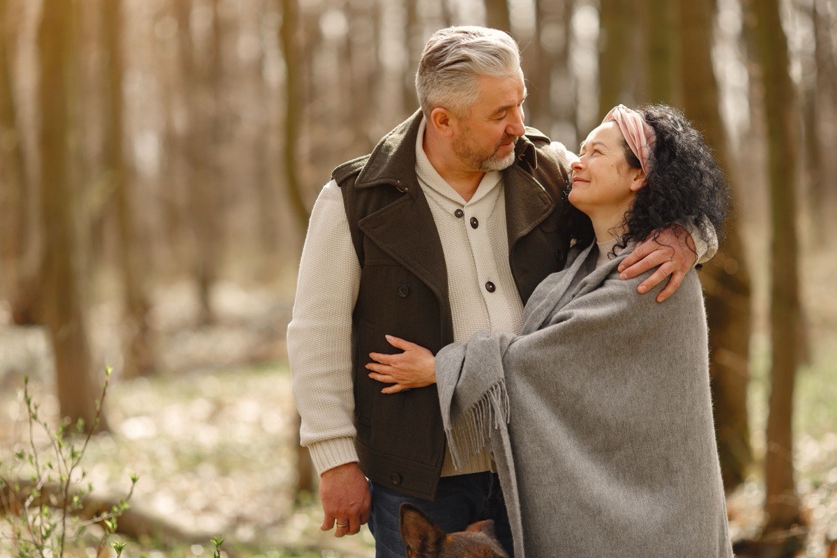 Mature couple embracing in a sunlit forest